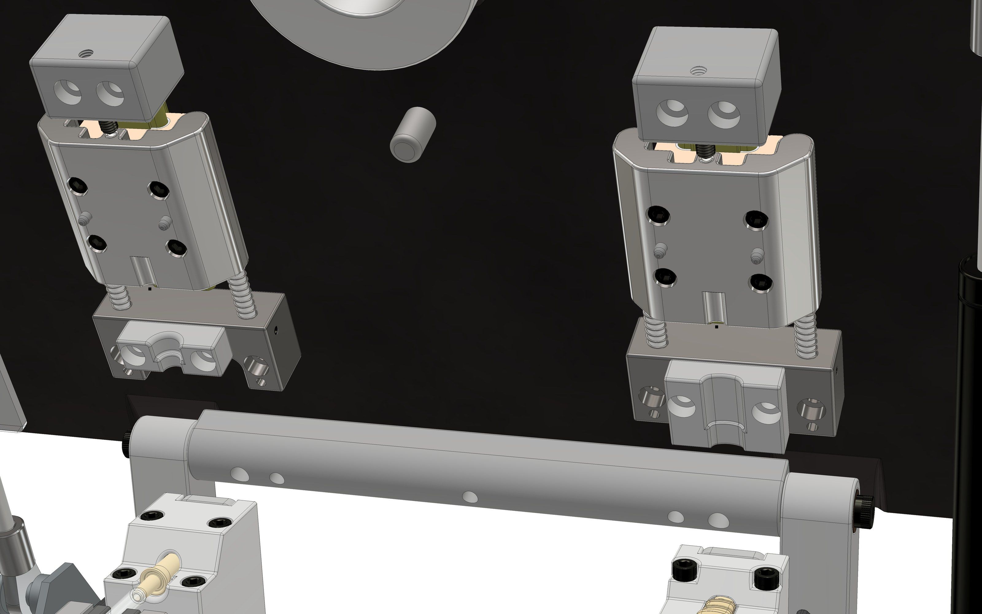 Close view of the two spring-loaded fitting clamps on the tool plate, the pivot bar beneath them, and two fittings with tubing seated in the lower nests
